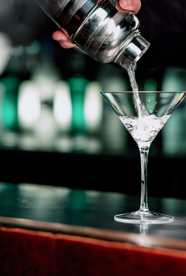 Pouring a cocktail into a martini glass. 