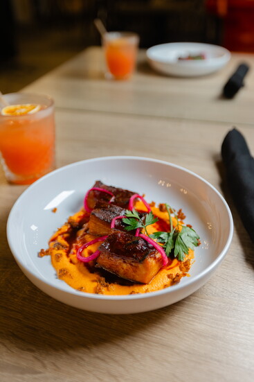 Neon Fig Pork Belly Smokey Romesco with Pickled Shallot and Chorizo Crumble