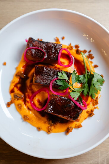 Neon Fig Pork Belly Smokey Romesco with Pickled Shallot and Chorizo Crumble