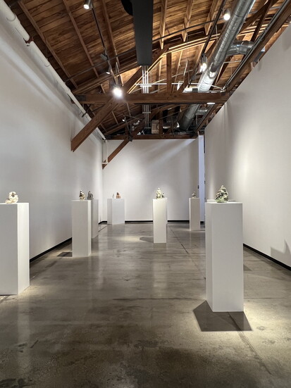 12-inch, hand-built scupltures of mothers embracing their children on display at Fay Ray's "Puerperal" exhibition at Compound Long Beach.