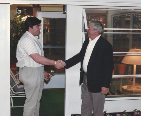 Mike Chekanoff shakes his father, Alex Chekanoff's, hand