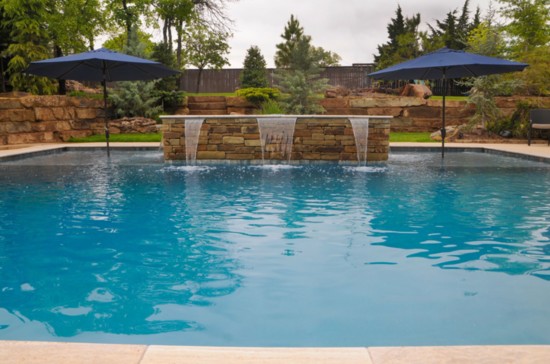The contemporary-style pool designed by Robert Powell features a fountain element, spa and seating area.