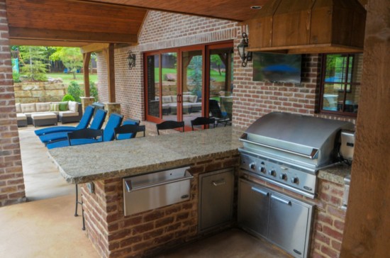 The existing outdoor kitchen was incorporated into the new addition of a pool house.