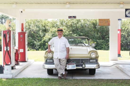 Dave Lanning at his replica garage with one of the automobiles in his collection.