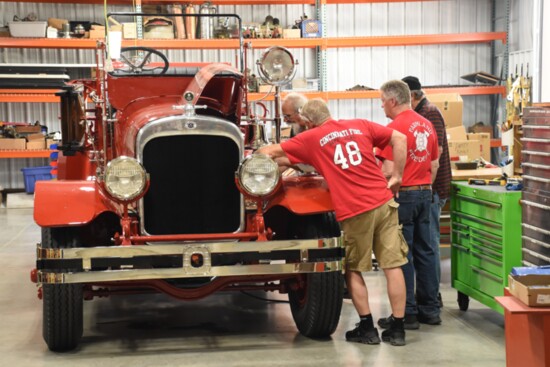 A team of mechanics working to restore an antique firetruck.