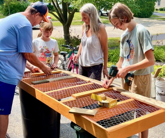 Nine-year-old June McCauley (L) and 11-year-old Willow McCauley (R) helped measure reclaimed wood, stapled chicken wire and drilled screws into the pieces.