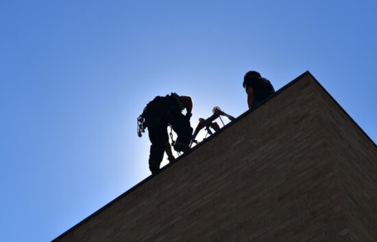 A firefighter hangs from the top of Arvada Fire’s Training Center, located on Indiana St., while conducting a high angle rescue drill. 