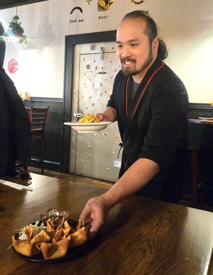 Inkfire manager Ken Ha delivers some crab puffs with a smile.