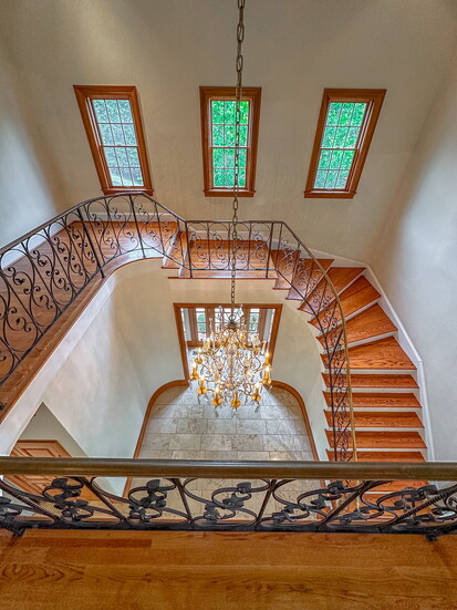 Wrought iron railings line the stunning staircase in the foyer.