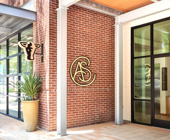A logo bearing the chef’s initials marks the restaurant entrance.