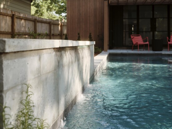 A cascading waterfall anchors the pool’s west side.