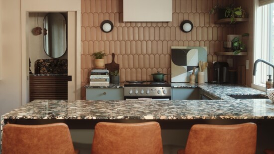 The kitchen takes center stage, with a glimpse of the bathroom in the background.