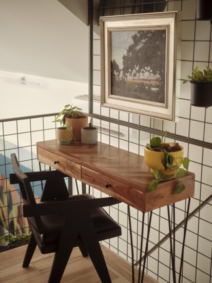 A metal mesh railing in the loft reaches toward the ceiling over a desk area, complemented by “Sunrise, Christmas Creek” by David Boyd from Spalding Nix Gallery