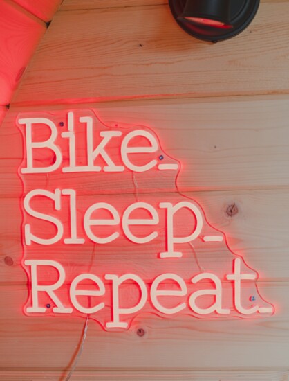 Bike, Sleep, Repeat. The slogan glowing in every The Bike Inn room.