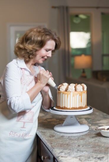 Rita preparing her delicous pumpkin spice cake with cinnamon butter cream and a  salted caramel drizzle. 