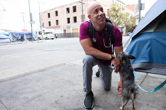 Compassion in action: Dr. Kwane examines a dog belonging to one of the unhoused.