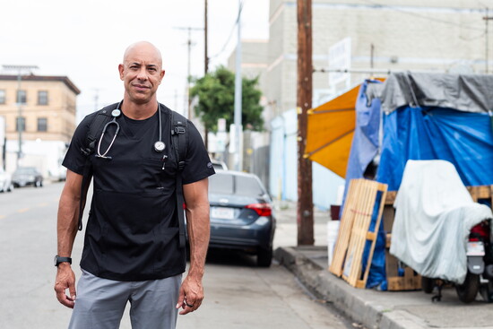 A moment of quiet strength — Stewart stands where his work so often begins: on the streets