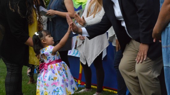 A young graduate of the Learning With Love program gives Sánchez a high-five. Photo: Valley Settlement