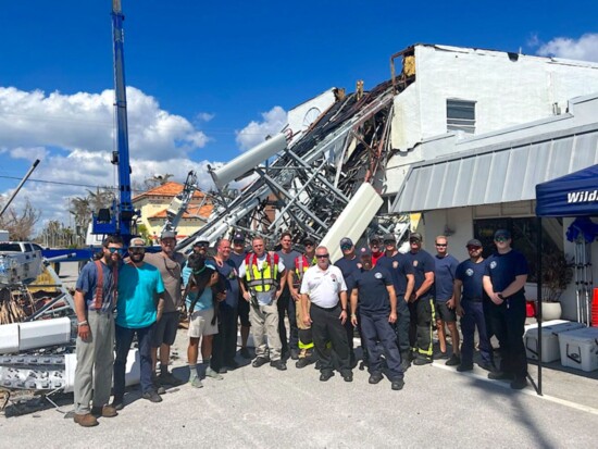 Members of Boca Grande FD and others gather after Hurricane Ian destroyed the building and an adjacent cell tower. 