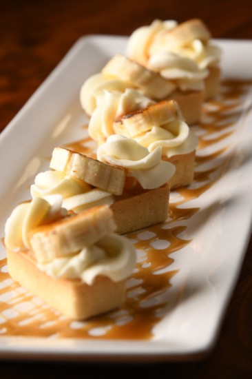 The Bruleed Banana Cream Tartlet is a smooth banana custard topped with bruleed banana, drizzled with butterscotch caramel.