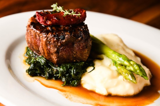 Filetto Rosso features a prime beef tenderloin, which is served with asparagus, garlic whipped potatoes, spinach, tomato, thyme, and a veal reduction