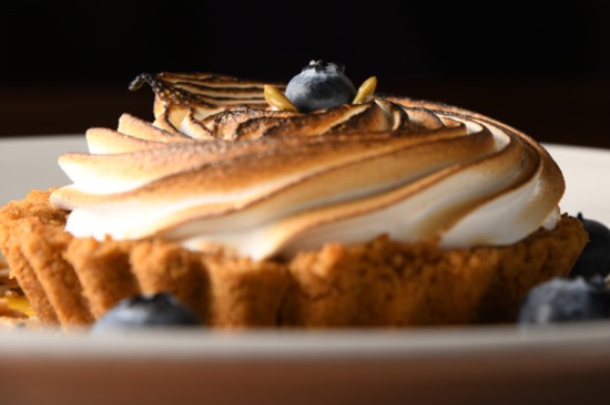 Benvenuti's Coconut Cream Tart features a graham cracker crust, topped with whipped meringue, toasted coconut and passionfruit sauce.