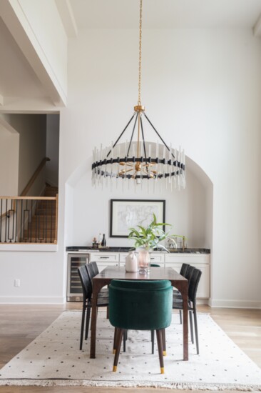 The formal dining area, which has line of sight to one of the living areas and the kitchen, features a wine/coffee bar and a dramatic chandelier.