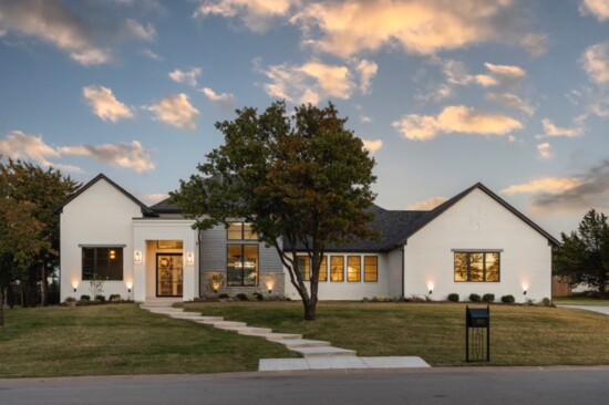 The home, located in The Falls addition in Edmond, sports a modern, stylish exterior with a clean, white-brick exterior that plays well with spot-on black trim.