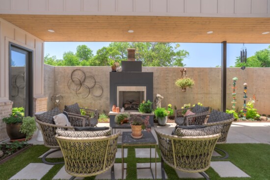 A large plaza fireplace takes center stage in this outdoor space. A 7’ poured-in-place concrete wall adds beauty and privacy.