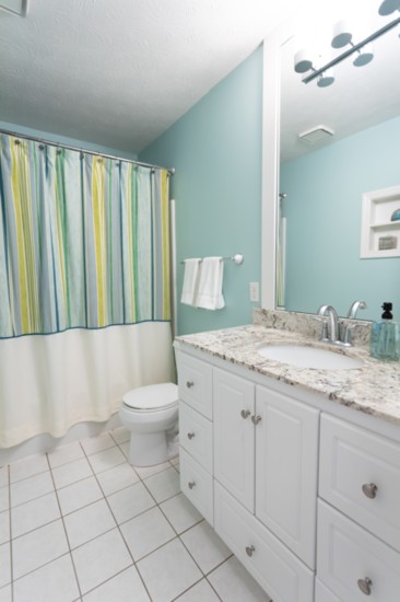 A total makeover! New vanity, sink, faucet and granite, as well as custom-framed mirror with new light fixture, shower curtain, towels and accessories.  