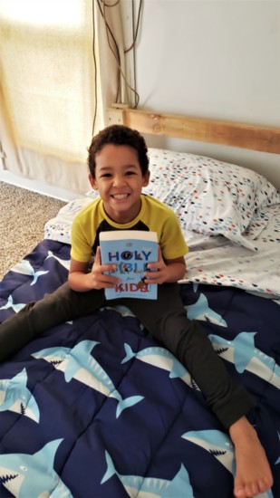 A happy child enjoys his new bed from SHP.