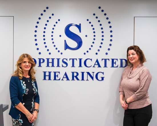 Dr. Donna Szabo and Dr. Ann Marie Olson standing in Sophisticated Hearing's lobby