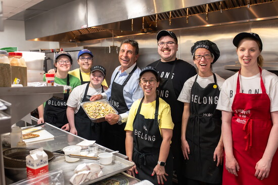 Chef Johnny Carrabba works alongside Belong Kitchen staff to prepare a special dish.