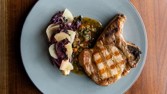 Grilled Local Pork Chop with grilled radicchio, pickled apples, and sauce robert.