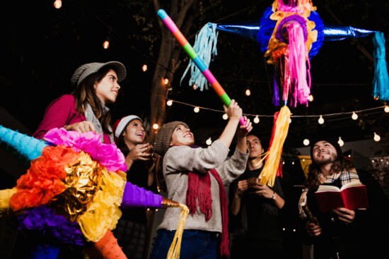 Friends break a piñata during Las Posadas.