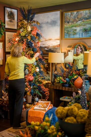 Rose McCormick arranges a tree at one of the many beautiful Christmas vignettes at her showroom.