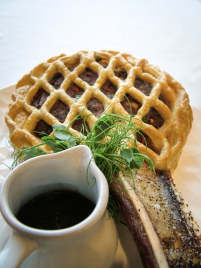 Bison Short Rib Lollipop with puff pastry, parsnips, carrots, peas, onion, and demi-glace