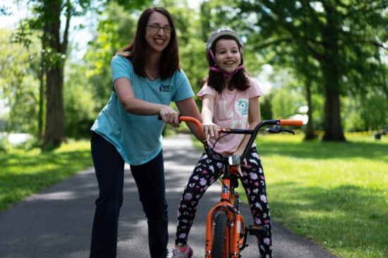 Dr. Joni Redlich demonstrates bicycling tips with her daughter, Sophie (7) 