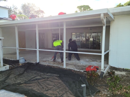 The crew demolishing the original screened in patio of the U-shaped home.