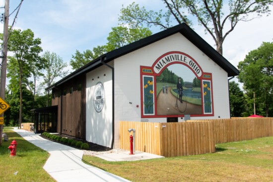 Honoring the history of Miamiville, the two-story mural of a high-wheeler bicycle is an artistic gem. 