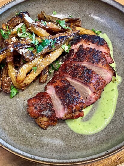 Smoked duck on a bed of poblano cream sauce w/side of duck fat cilatnro-garlic fries 