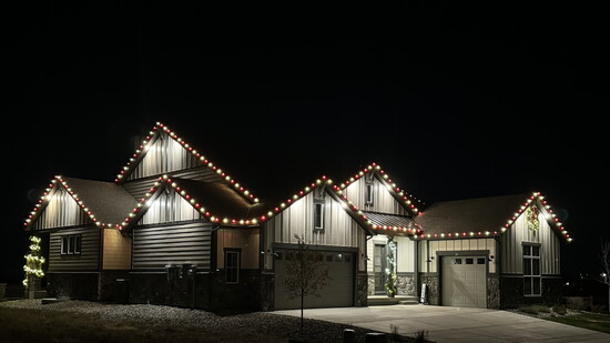 Crisp, professional roofline lights highlight this gorgeous home’s architectural details for a polished holiday display.