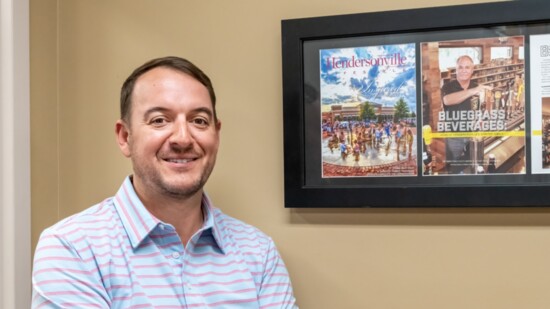 Bluegrass Beverages owner stands by a photo montage that depicts his uncle and previous store owner Bill Sinks Jr.
