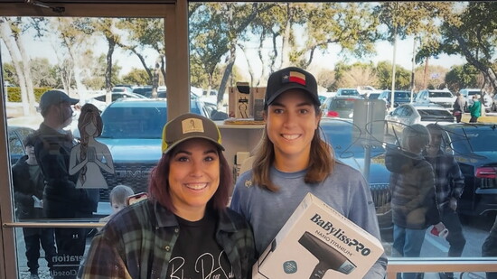 Allison Bryant celebrates the Blue Door Salon scavenger hunt winner with prizes.