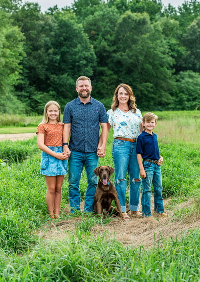 Left to right are Cora-Lee, Ryne, Heather and Major Ashley. Chocolate lab Nitro is in front. 