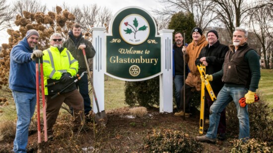 Members of the Rotary Club of Glastonbury installing a welcome sign for the town