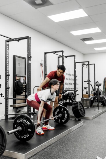 Pete coaches Zoey Applebaum as she prepares to do a set of deadlifts.