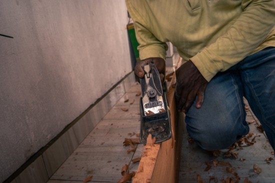 A carpenter working on the interior design of a low-income housing project