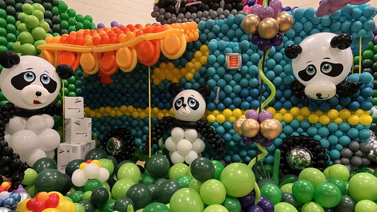 Whimsy meets wow in this playful panda paradise where every detail, from the floral flourishes to the bus, is crafted entirely from balloons.