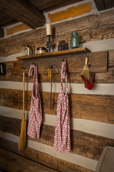 Utensils hang from hand-hewn pegs in the interior of the Cabin in the Clearing at Keehner Park.